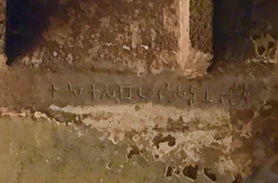 A weathered Brahmi-script inscription carved into stone at the Ajanta Caves, Maharashtra.