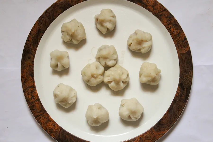 A plate of small modaks arranged for offering.