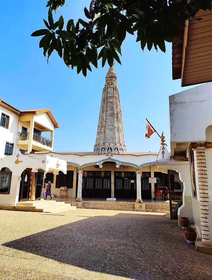 The tall, tiered spire of the Hindu Monastery of Africa in Accra, Ghana, seen across its courtyard.