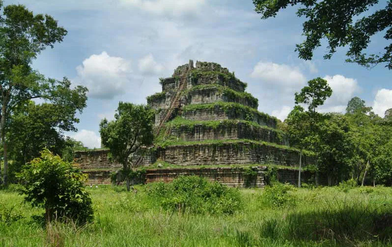 The tiered stone pyramid of Prasat Thom at Koh Ker, Cambodia, overgrown with jungle vegetation.
