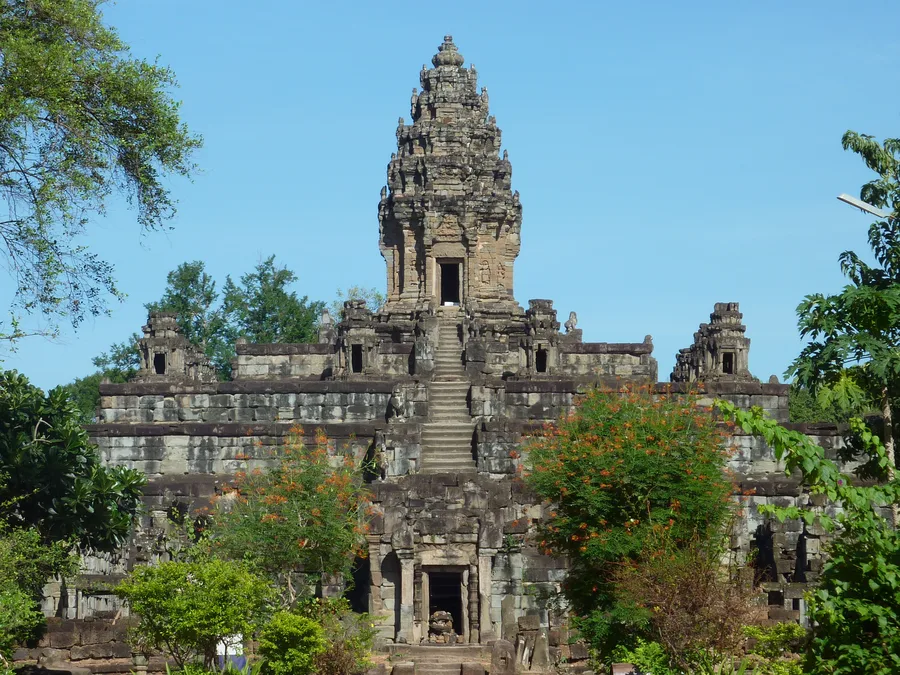 The central stepped tower of the Bakong temple at Angkor, Cambodia, rising above surrounding trees.