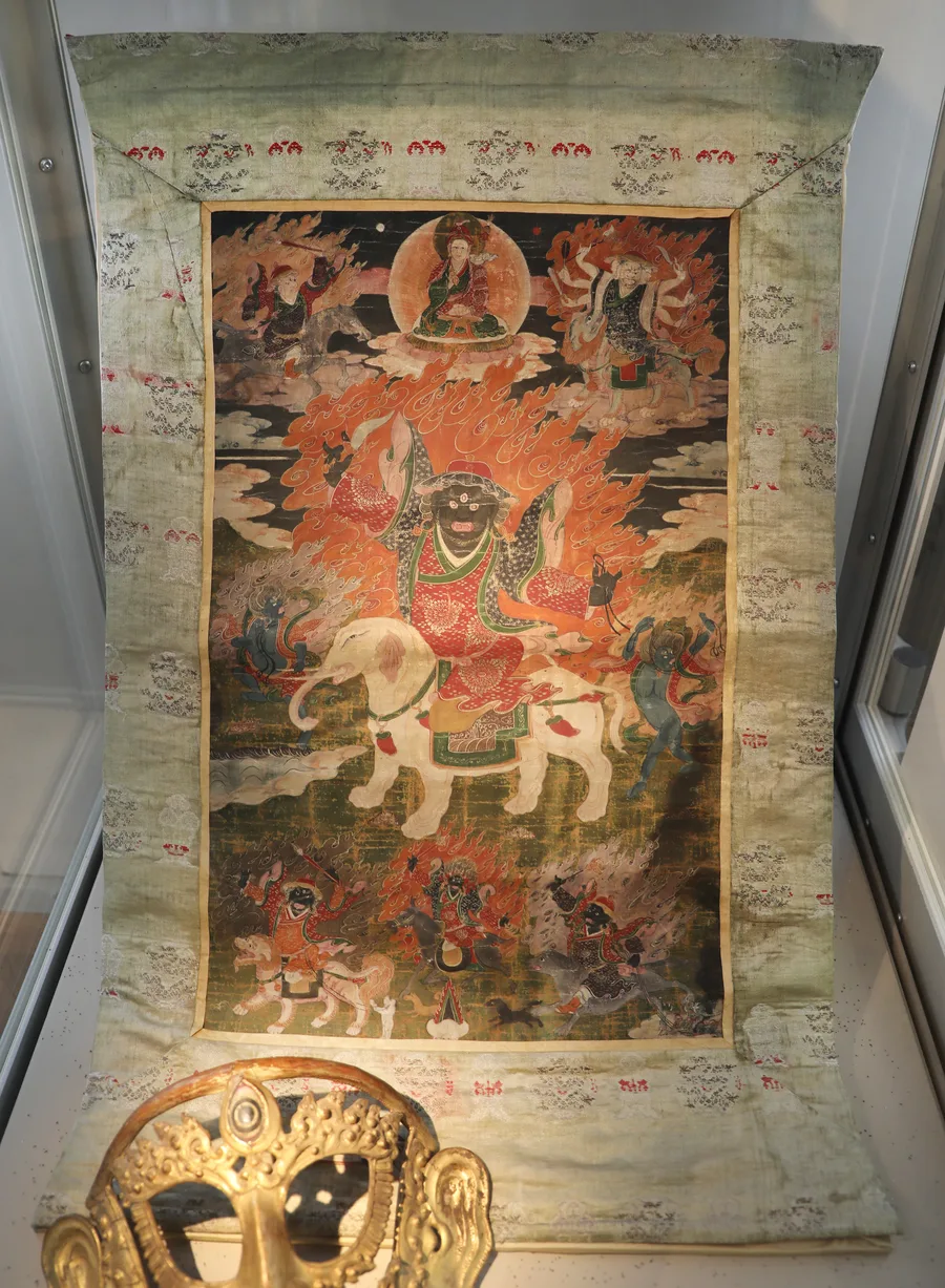 A nineteenth-century Tibetan thangka painting depicting Mahakala riding a white elephant, surrounded by flames.