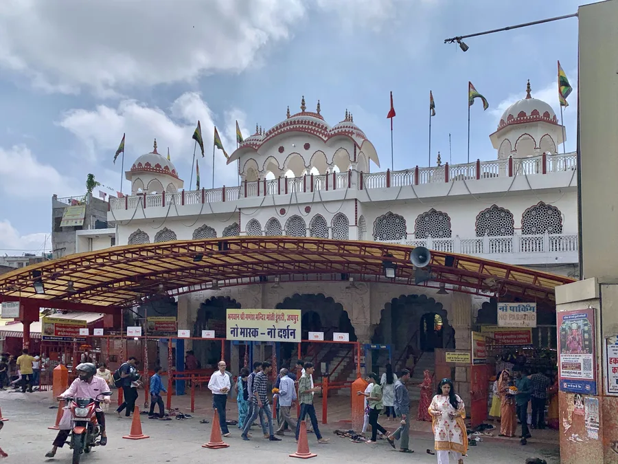 The domed, whitewashed towers of the Moti Dungri Ganesh temple in Jaipur, decorated with flags.